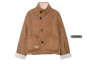 Detail of a brown suede jacket with white faux shearling lining and button pockets