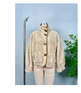 Close-up of beige reversible fleece jacket with stand collar and brown piping detail