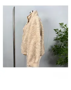 Detail of a beige reversible faux fur jacket featuring a stand collar and thick texture
