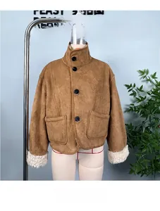 Detailed view of brown faux suede jacket featuring warm white faux shearling lining and buttons