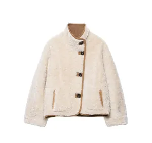 Detail of cream fleece jacket featuring stand collar and brown leather contrast trim