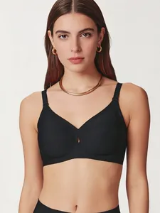 Detail of a black deep V-neck seamless bra featuring a teardrop cutout design