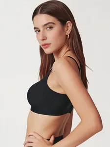Side view of seamless black wireless bra with thin straps on a professional model