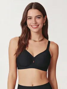 Detailed view of black seamless bra featuring a teardrop cutout and sleek elastic fabric