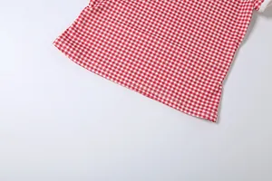 Détail du tissu à carreaux rouges avec couture d'ourlet soignée sur le t-shirt