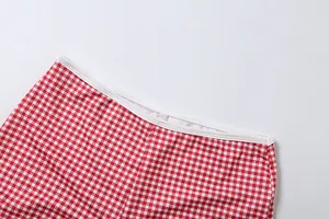 Gros plan sur le motif vichy rouge et la taille élastique du short de sport ajusté