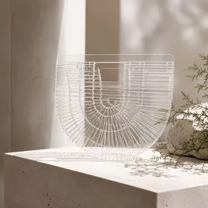 Close-up of semi-circle acrylic basket bag with hollow slats on stone surface