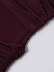 Macro shot of burgundy mesh dress featuring ruched fabric and sheer mesh details