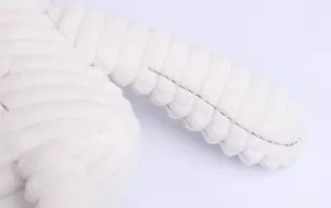 Detailed macro view of plush rabbit toy featuring striped texture and durable white stitching