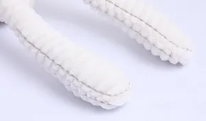 Close-up of white plush rabbit toy showing ribbed corduroy texture and fine stitching detail