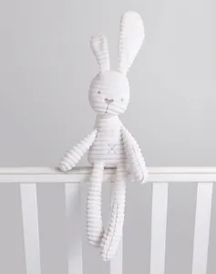 Close-up of white corduroy plush bunny with long ears and striped texture for infants