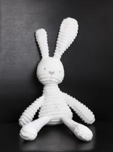 Close-up of white plush bunny toy featuring soft corduroy texture and pink embroidery details