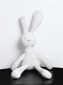 Close-up of white plush bunny toy featuring soft corduroy texture and pink embroidery details