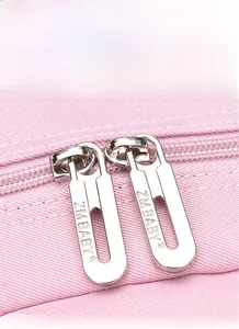 Detailed close-up of premium silver dual metal zippers on a pink fabric school backpack