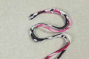 Dettaglio dei lacci con stampa leopardata rosa e nera di un set sexy schiena scoperta