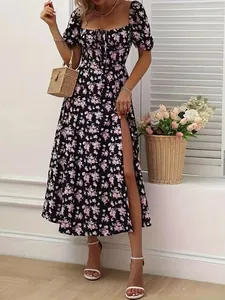 Detailed view of black floral dress featuring a high slit and romantic puff sleeves