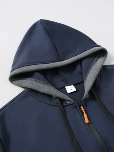Détail du sweat à capuche bleu avec doublure grise, zip orange et étiquette de taille M