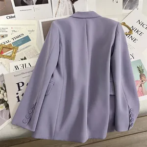 Close-up of lilac blazer sleeve with four tonal buttons and pocket detail on a flat lay