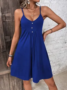 Dettaglio di un abito in maglia blu scuro con scollo a V, bottoni in legno e pieghe morbide