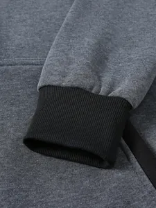 Gros plan détaillé du tissu gris foncé du sweat à capuche et poignets côtelés noirs