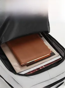 Detail of front zipper pocket on light grey backpack storing notebooks and magazines