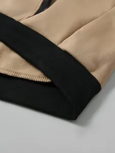 Gros plan sur la manche du sweat à capuche kaki et noir avec poignets côtelés et coutures