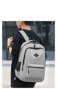 Detail showing the side USB charging port and gray fabric texture of the casual backpack