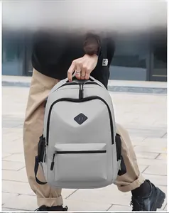 Detail of light grey travel backpack showing side USB charging port and mesh pocket