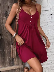 Dettaglio abito in maglia bordeaux con scollo a V, bottoni decorativi e vita a pieghe
