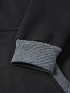 Détail du sweat à capuche en coton noir avec poignets en maille côtelée grise serrée