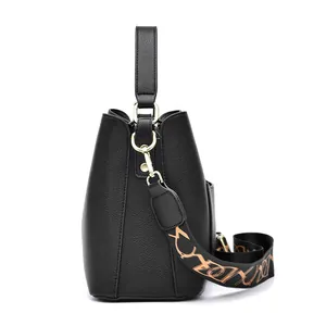 Borsa a secchiello in pelle nera con tracolla jacquard larga e finiture oro