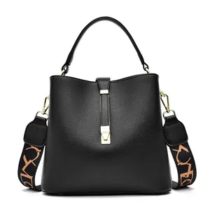 Borsa a secchiello chic in pelle nera con tracolla a fantasia e chiusura dorata
