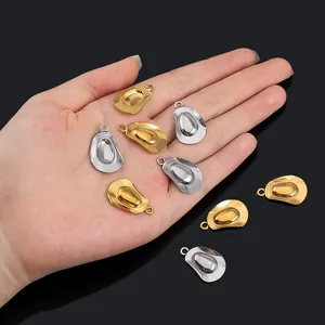 Close-up of gold and silver cowboy hat charms held in palm for scale comparison