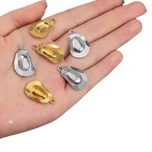 Polished gold and silver stainless steel cowboy hat pendants shown in hand for size
