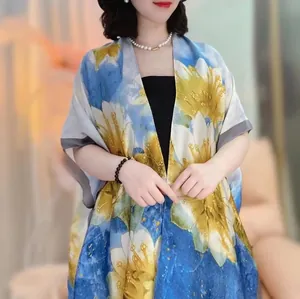 Close-up of lightweight satin sun protection shawl with vibrant blue and yellow floral prints