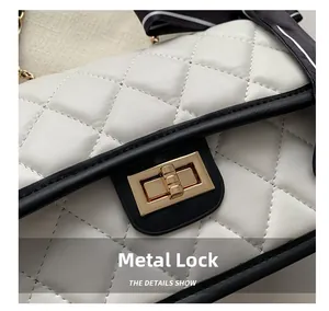 Detailed close-up of the golden hardware lock and quilted white leather on the bag