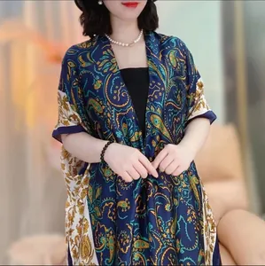 Close-up of smooth satin fabric featuring classic blue paisley pattern on sun shawl