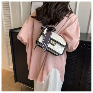 Detail view of quilted leather crossbody bag with scarf and golden twist-lock closure