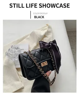 Detail of black quilted leather shoulder bag with gold twist lock and decorative silk scarf
