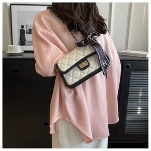 Close-up of quilted chain crossbody bag with H-pattern silk scarf and gold twist lock