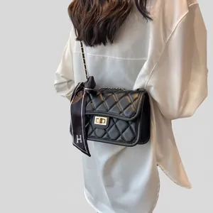 Chic black quilted crossbody bag with gold lock, chain strap and H-pattern silk scarf