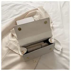 Detailed interior of a white embossed leather flap bag showing magnetic closure and space