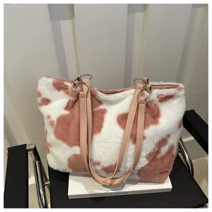 Nahaufnahme der flauschigen Plüschtasche mit Kuhmuster und hochwertigem Ledergriff