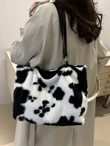 Modische Plüsch-Schultertasche mit Kuhmuster, getragen von einem Modell im Trenchcoat