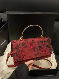 Elegant red embroidered handbag with floral butterfly patterns in a luxury gift box