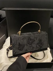 Elegant black lace crossbody bag with gold handle and butterfly applique in a gift box
