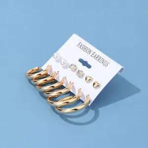 Detailed set of 6 pairs of gold fashion earrings with pearls and crystals on blue card