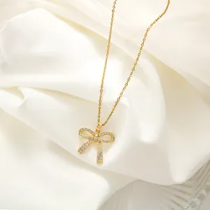 Elegante goldene Schleifenkette mit Zirkonia auf weißem Seidenhintergrund