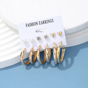 Fashion 6-pair gold earrings set with pearls, zircons, and hoops on a white card