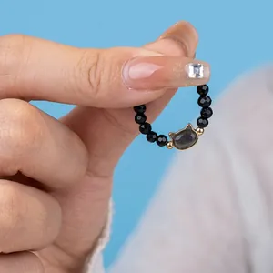 Close-up of beaded cat ring featuring black obsidian beads and cat eye opal center